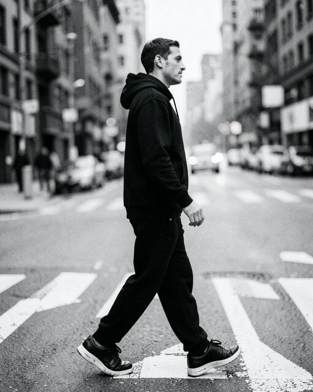 Man crossing the street in a Karbon black hoodie